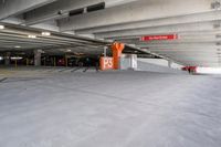 an underground parking garage with concrete floors, cement walls and multiple orange painted do not enter signs