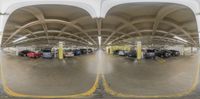 an underground parking lot, with several vehicles in it and yellow paint painted lines on the floor