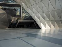 an underground area with a staircase in the middle of it with metal design on the walls