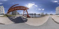 a 360 view of a bridge and buildings on the water side, from underneath, over looking a city