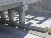 a parking space that is under a large concrete building with a fire hydrant on the sidewalk