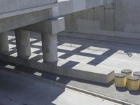 a parking space that is under a large concrete building with a fire hydrant on the sidewalk