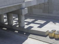 a parking space that is under a large concrete building with a fire hydrant on the sidewalk