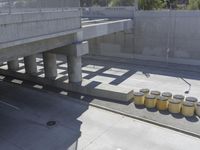 a parking space that is under a large concrete building with a fire hydrant on the sidewalk