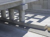 a parking space that is under a large concrete building with a fire hydrant on the sidewalk