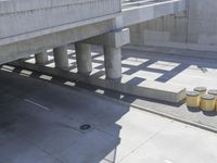 a parking space that is under a large concrete building with a fire hydrant on the sidewalk