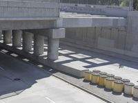 a parking space that is under a large concrete building with a fire hydrant on the sidewalk