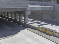 a parking space that is under a large concrete building with a fire hydrant on the sidewalk