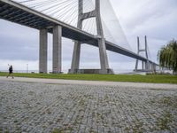 the view from under a bridge of a road and a grass field in front of it