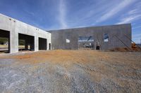 an unfinished building in the process of being built and placed on a gravel surface at a construction site