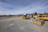 several heavy machinery are standing in a field at the end of an unfinished construction site