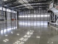 an unfinished warehouse floor with two sets of stairs on each side and one going up