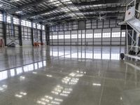 an unfinished warehouse floor with two sets of stairs on each side and one going up