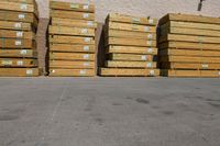 pallets in an unfinished warehouse sitting outside a building on a sidewalk next to a stack of yellow crates