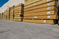 pallets in an unfinished warehouse sitting outside a building on a sidewalk next to a stack of yellow crates