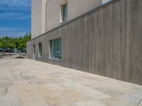 the gray concrete walls of a building have a line of steps on the left side