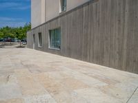 the gray concrete walls of a building have a line of steps on the left side