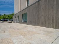 the gray concrete walls of a building have a line of steps on the left side