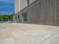 the gray concrete walls of a building have a line of steps on the left side