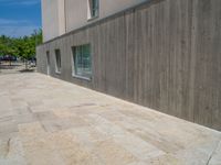 the gray concrete walls of a building have a line of steps on the left side