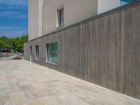 the gray concrete walls of a building have a line of steps on the left side