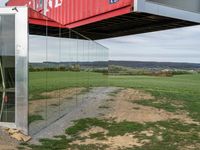 a container suspended off the side of a building on top of a field near a field