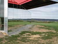 a container suspended off the side of a building on top of a field near a field