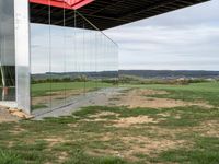 a container suspended off the side of a building on top of a field near a field