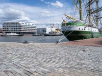 a dock with an unloading cargo ship docked in the harbor with a dock rope