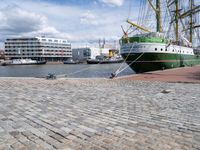 a dock with an unloading cargo ship docked in the harbor with a dock rope