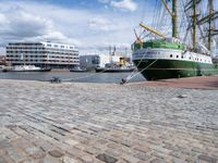 a dock with an unloading cargo ship docked in the harbor with a dock rope