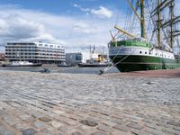 a dock with an unloading cargo ship docked in the harbor with a dock rope