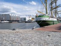 a dock with an unloading cargo ship docked in the harbor with a dock rope