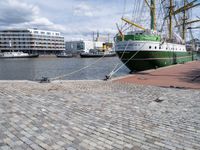 a dock with an unloading cargo ship docked in the harbor with a dock rope