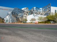 the building is designed like an unusual cube with some metal and stone construction on it