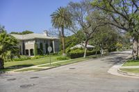 street corner at an upscale residential area with palm trees in foreground and apartment complex to the right