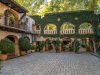 an alley with arches and potted plants on either side of it to make it easier to find a room