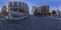 the photo was taken on a 360 - degree view from the intersection on a road in a city