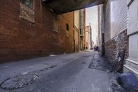 a street in an alley with two lanes full of brick and broken out doors and garbage on the ground