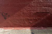 a wall with graffiti on it showing an angry expression to a man holding a cat