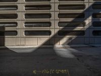 a black fire hydrant stands next to an apartment building that has large windows in the wall