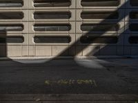 a black fire hydrant stands next to an apartment building that has large windows in the wall