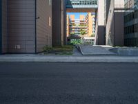 a road through which is a large modern building with an awning over it's entrance