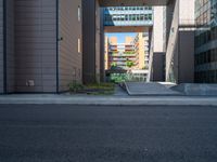 a road through which is a large modern building with an awning over it's entrance