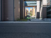 a road through which is a large modern building with an awning over it's entrance