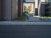 a road through which is a large modern building with an awning over it's entrance