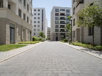 a walkway leads through two high rise apartment buildings in an urban setting outside a city