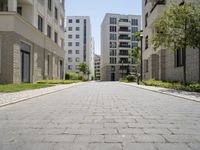 a walkway leads through two high rise apartment buildings in an urban setting outside a city