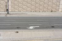 a white arrow painted on the side of a road in the middle of nowhere,