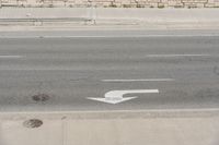 a white arrow painted on the side of a road in the middle of nowhere,